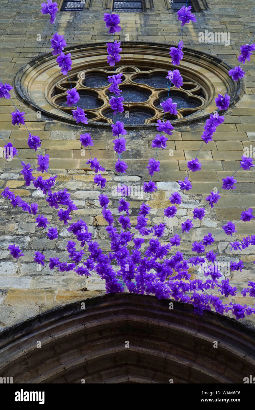 Purple festival flowers hanging from a French church Stock Photo