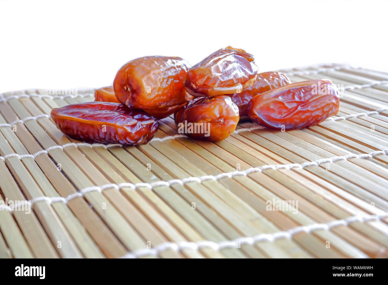 Dried fruits of date palm on bamboo mat background, Phoenix dactylifera on bamboo mat. Stock Photo