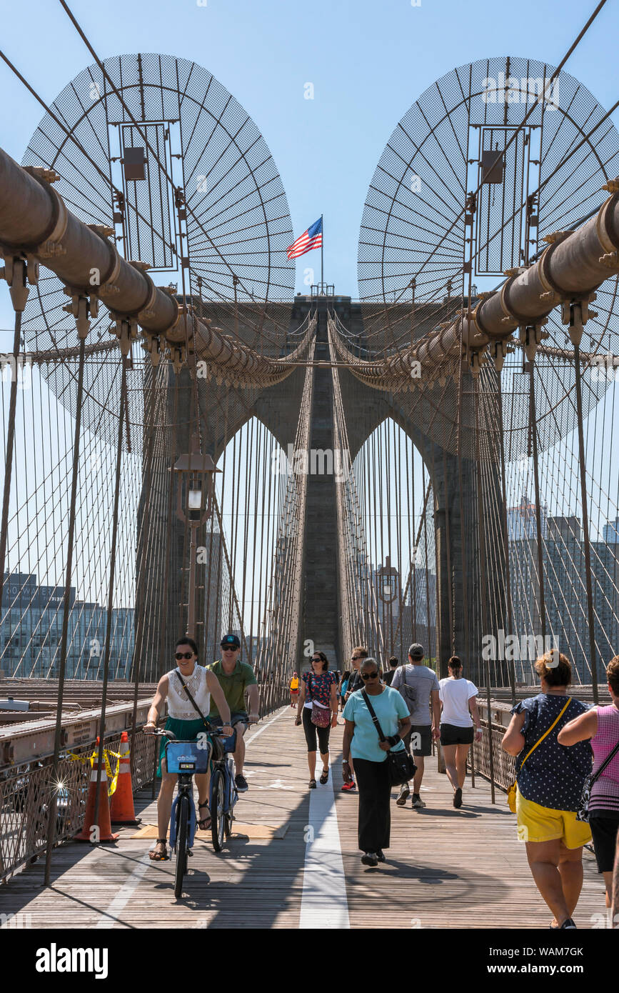 Brooklyn Bridge, view in summer of people walking and cycling across the Brooklyn Bridge, New York City, USA. Stock Photo