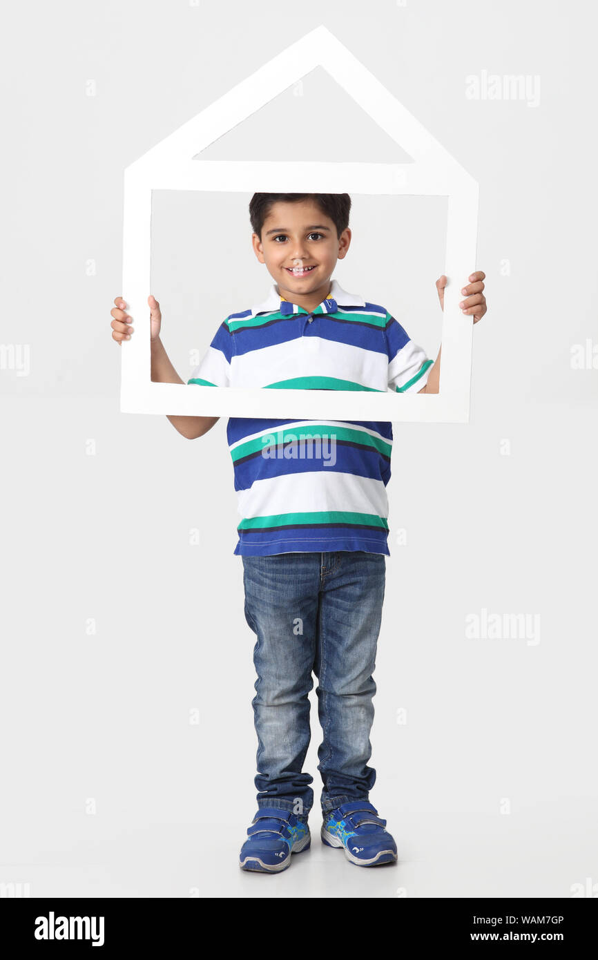 Boy holding a dream home shape frame Stock Photo