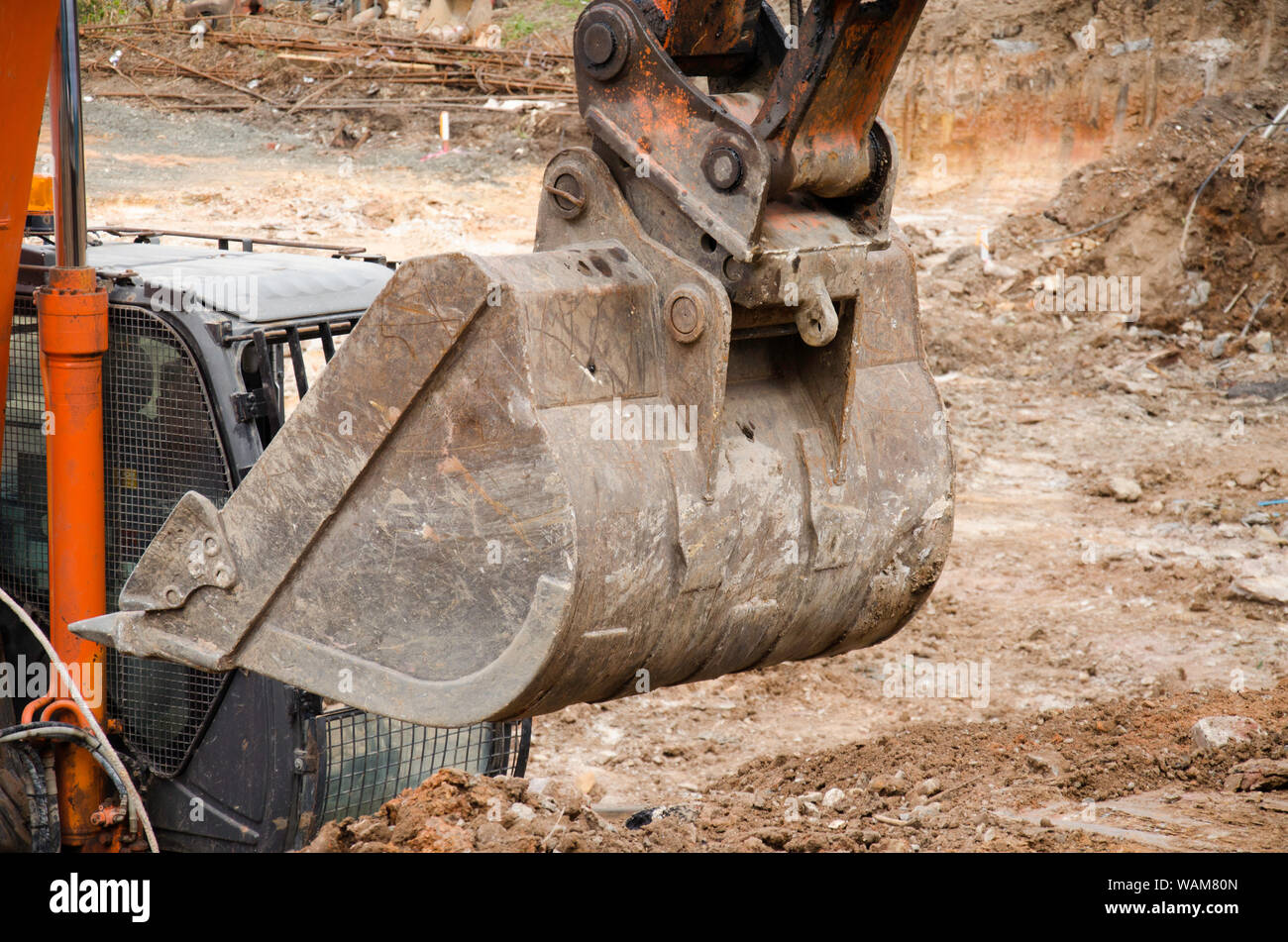 Premium Photo  A bucket excavator clears the roadside. road works. laying  a new road. loading excavator clay and a stones