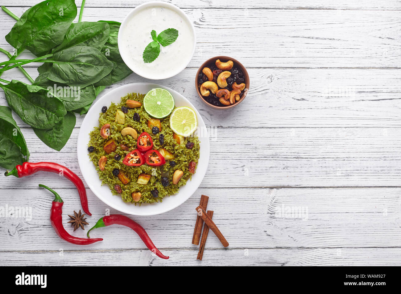 Palak Paneer Biryani and Raita at white wooden background with decor