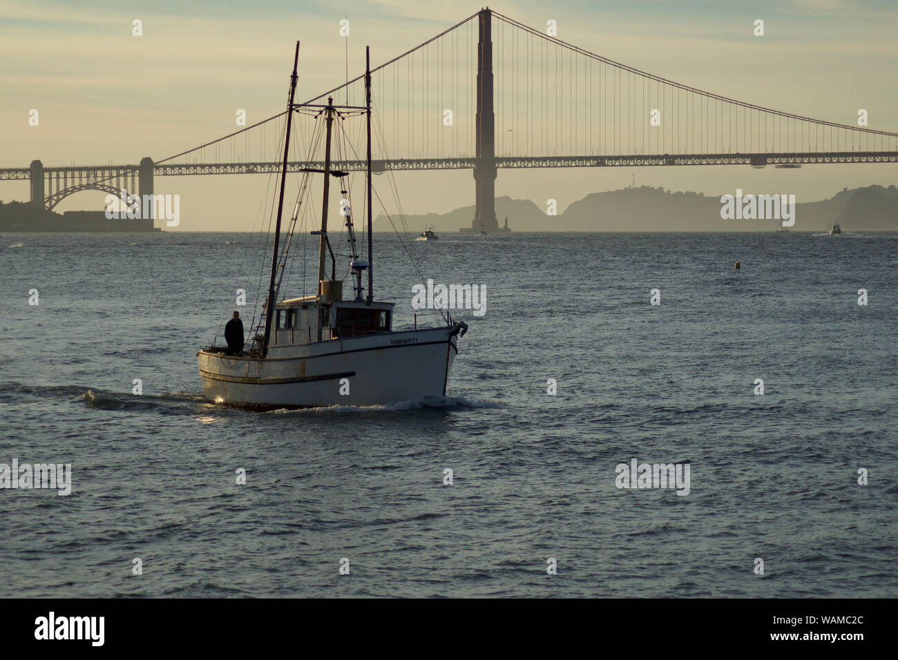 SAN FRANCISCO, CALIFORNIA, UNITED STATES - NOV 25th, 2018: Boat in San Francisco Bay with Golden Gate Bridge in the background during sunset Stock Photo