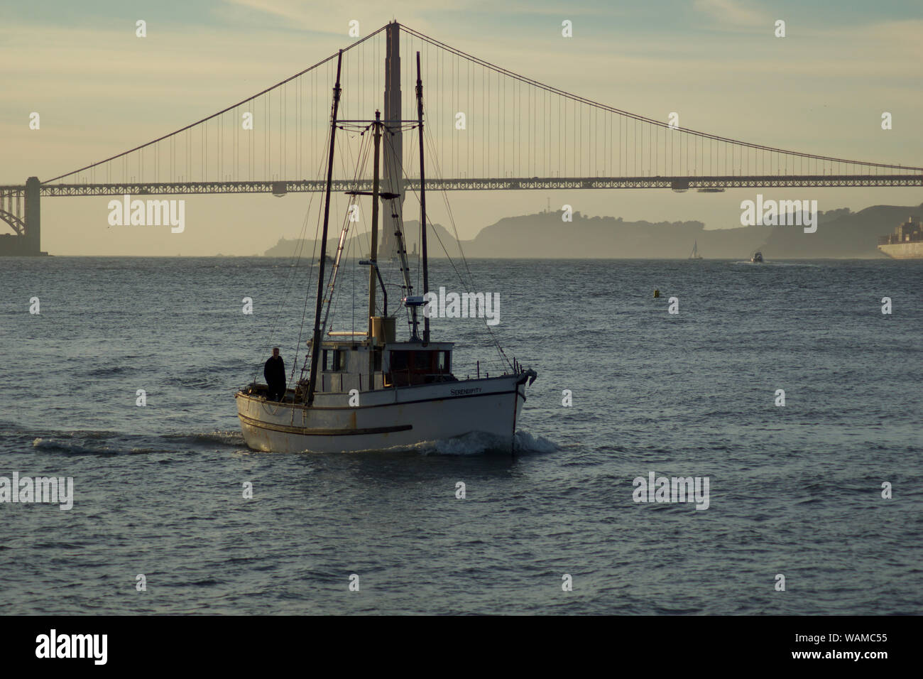 SAN FRANCISCO, CALIFORNIA, UNITED STATES - NOV 25th, 2018: Boat in San Francisco Bay with Golden Gate Bridge in the background during sunset Stock Photo