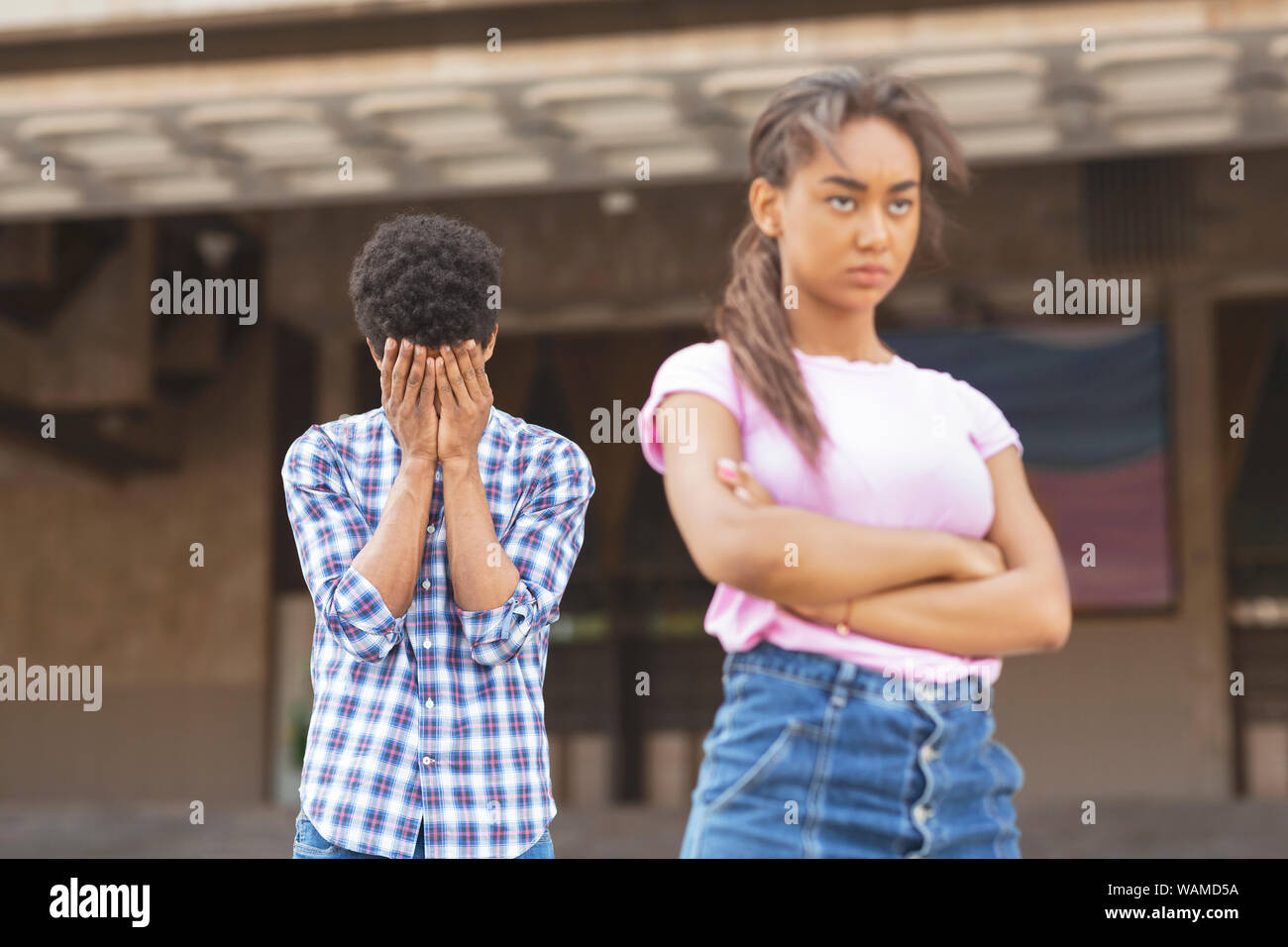Teenagers having relationship difficulties. Girl sulking to her upset boyfriend Stock Photo