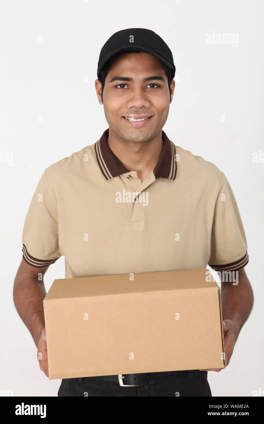 Delivery man holding parcel and smiling Stock Photo Alamy
