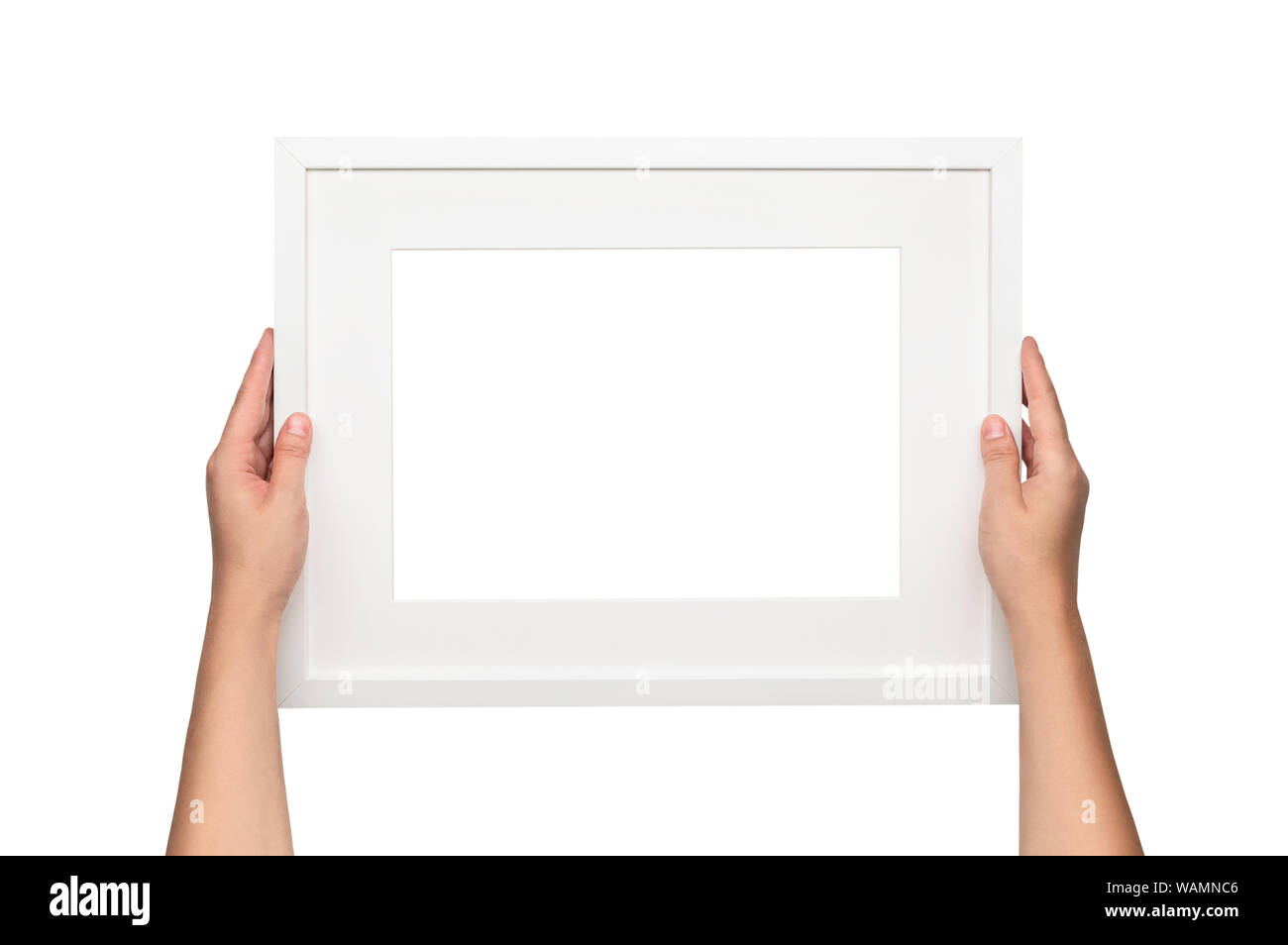 White frame. Woman hanging a frame on the wall. Empty white frame template. Stock Photo