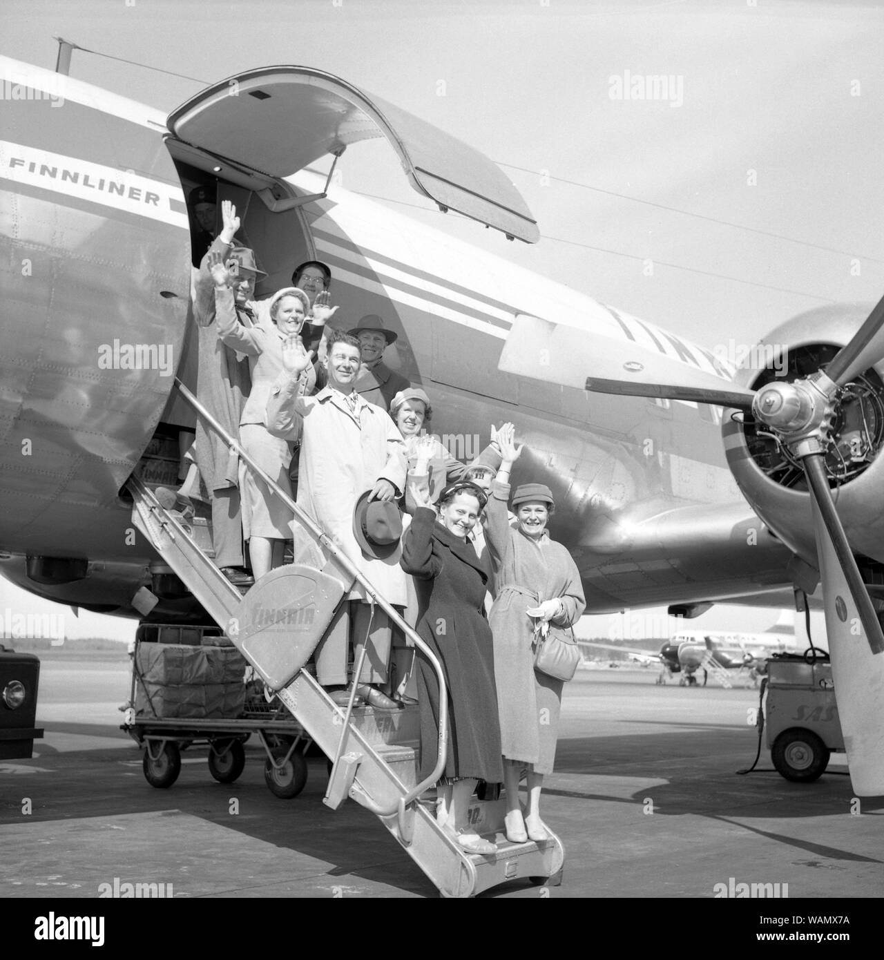 1950s vacation. A group of elderly people are standing on the stairs to an aircraft waving goodbye. Bromma airport Stockholm 1958. ref 3752 Stock Photo
