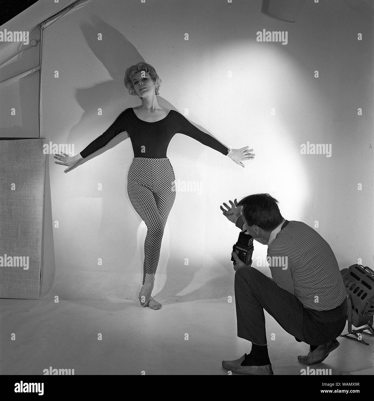 1950s photographer. A woman is posing for a photographer wearing a typical 1950s black jumper and patterned trousers. Sweden 1958. Ref CC96-2 Stock Photo
