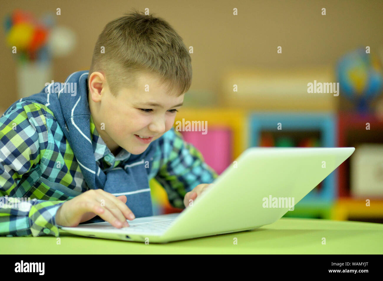 Cute boy using laptop and posing in room at home Stock Photo - Alamy