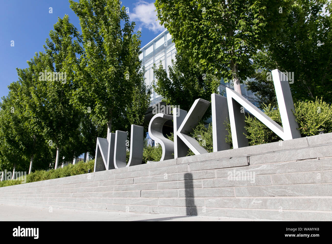 A logo sign outside of the headquarters of Nu Skin Enterprises in Provo