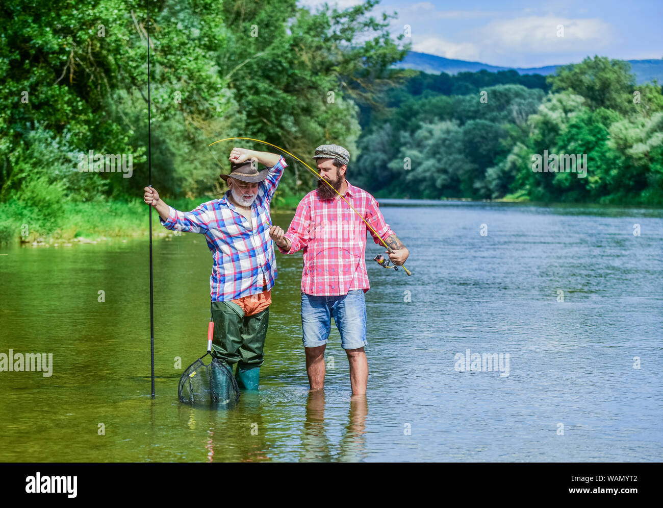Fishing freshwater lake pond river. Mature man with friend fishing