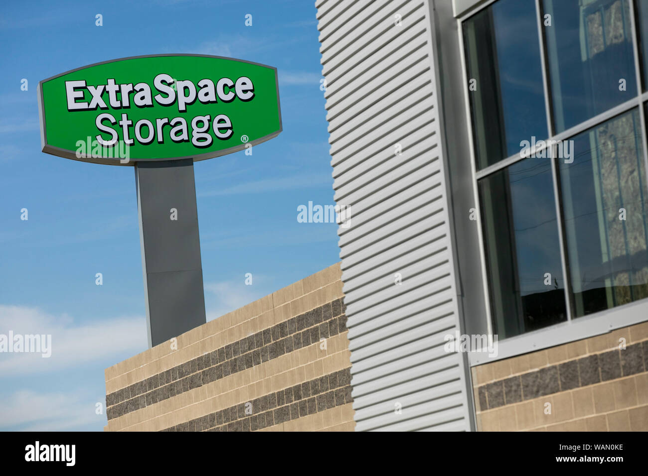 A logo sign outside of a facility occupied by Extra Space Storage in