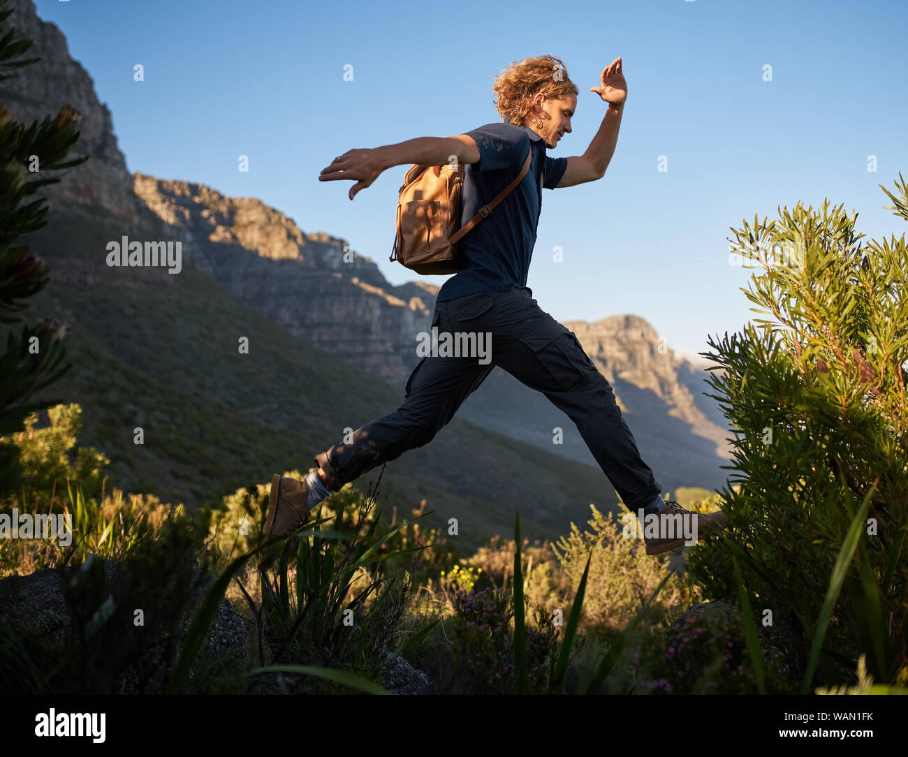 Man jumping high up on a mountain hike Stock Photo