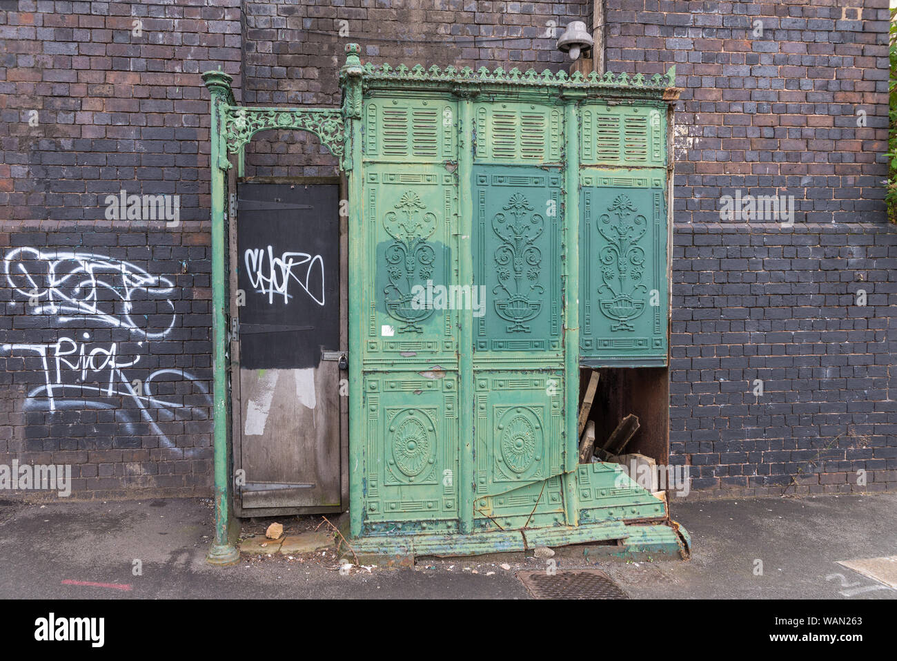 Broken old green cast iron men's urinal in Great Barr Street, Digbeth, Birmingham, UK Stock Photo