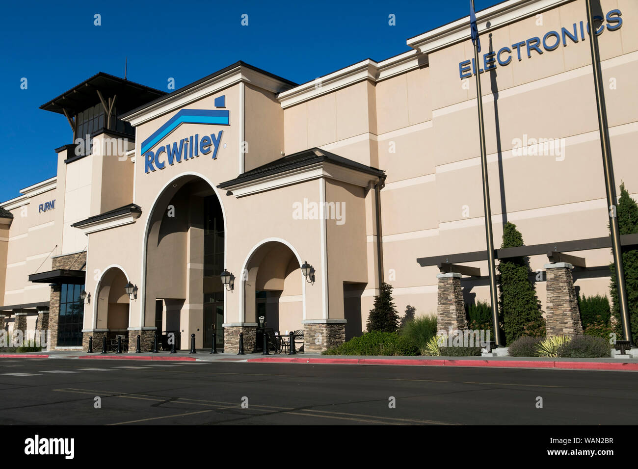 A logo sign outside of a RC Willey Home Furnishings retail store