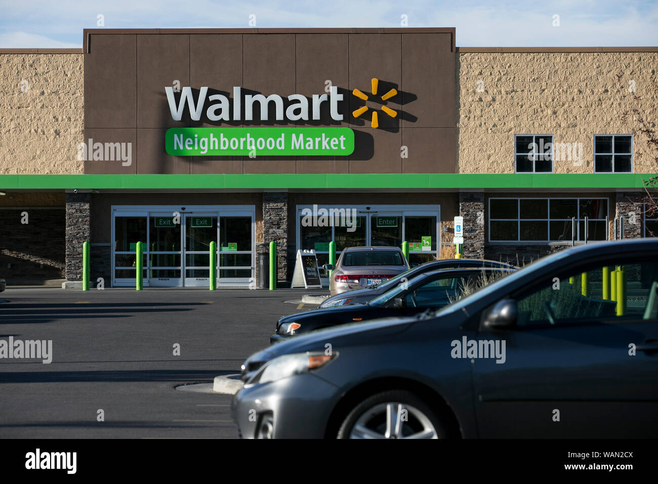 A logo sign outside of a Walmart Neighborhood Market retail store