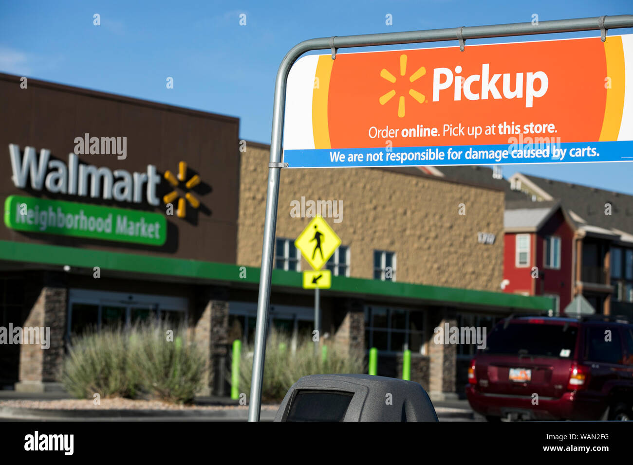 A logo sign outside of a Walmart Neighborhood Market retail store