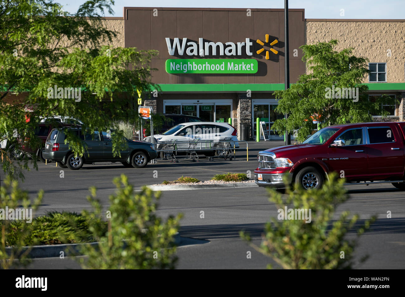 A logo sign outside of a Walmart Neighborhood Market retail store