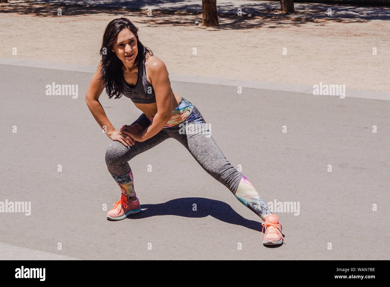 Young woman warming up before exercise in the middle of the park Stock Photo