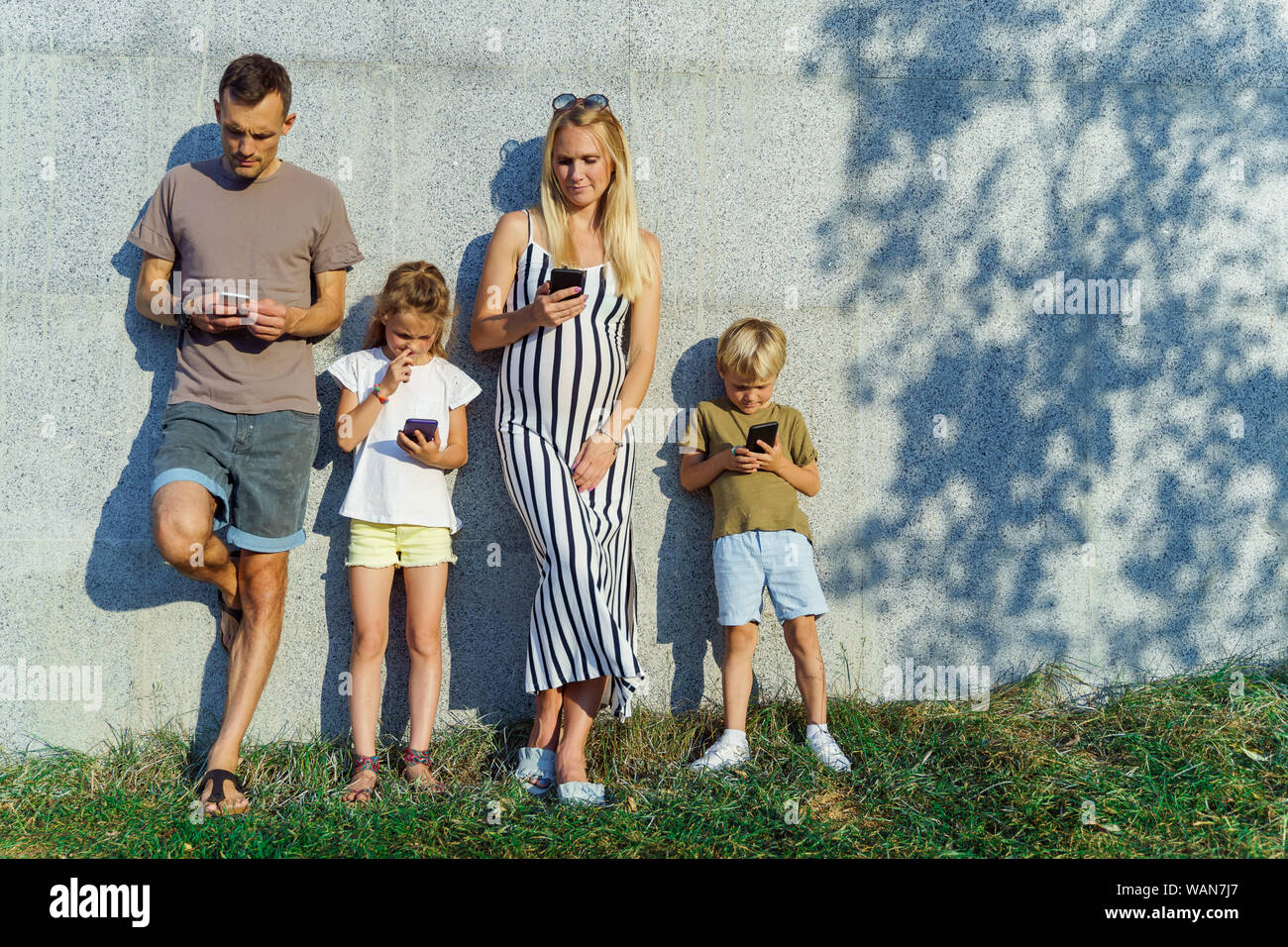 Image of parents and children with phones in their hands standing on ...