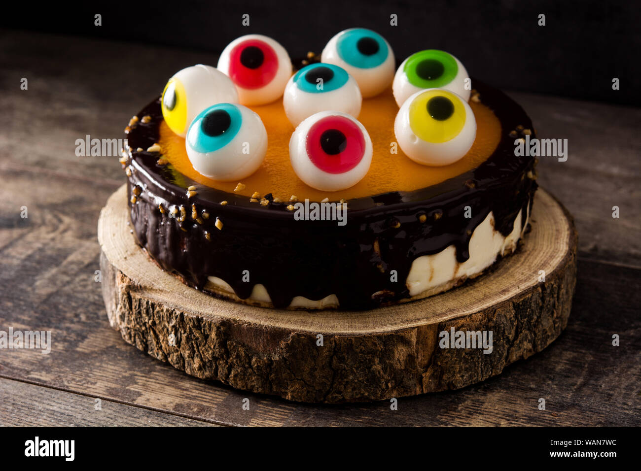 Halloween cake with candy eyes decoration on wooden table Stock ...