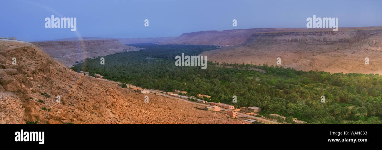 Panorama of an oasis in desert Sahara. A channel of the dried up river. Stock Photo