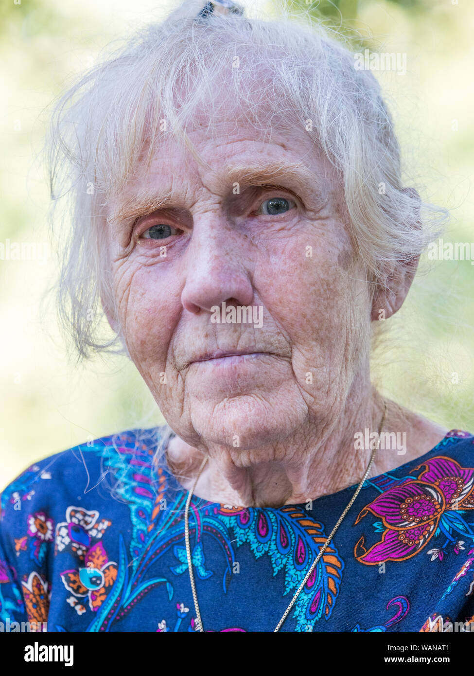 An elegantly dressed, elderly woman is sitting on a park benchis sitting on a park bench. Poland. Stock Photo