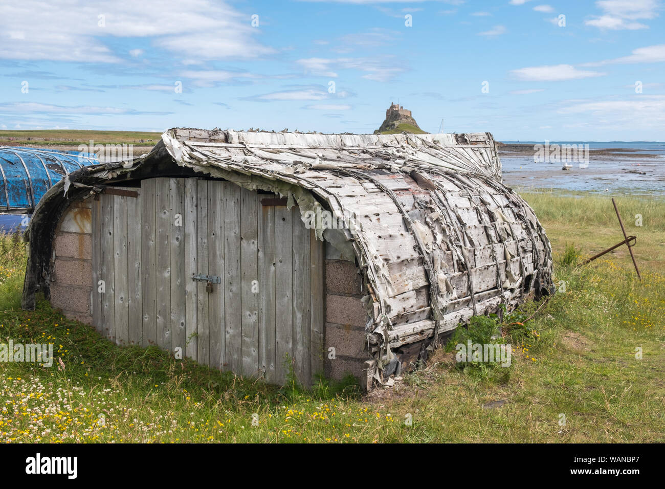 The traditional boat sheds on The Holy Island of Lindisfarne in Northumberland, UK are made from upturned fishing boats Stock Photo