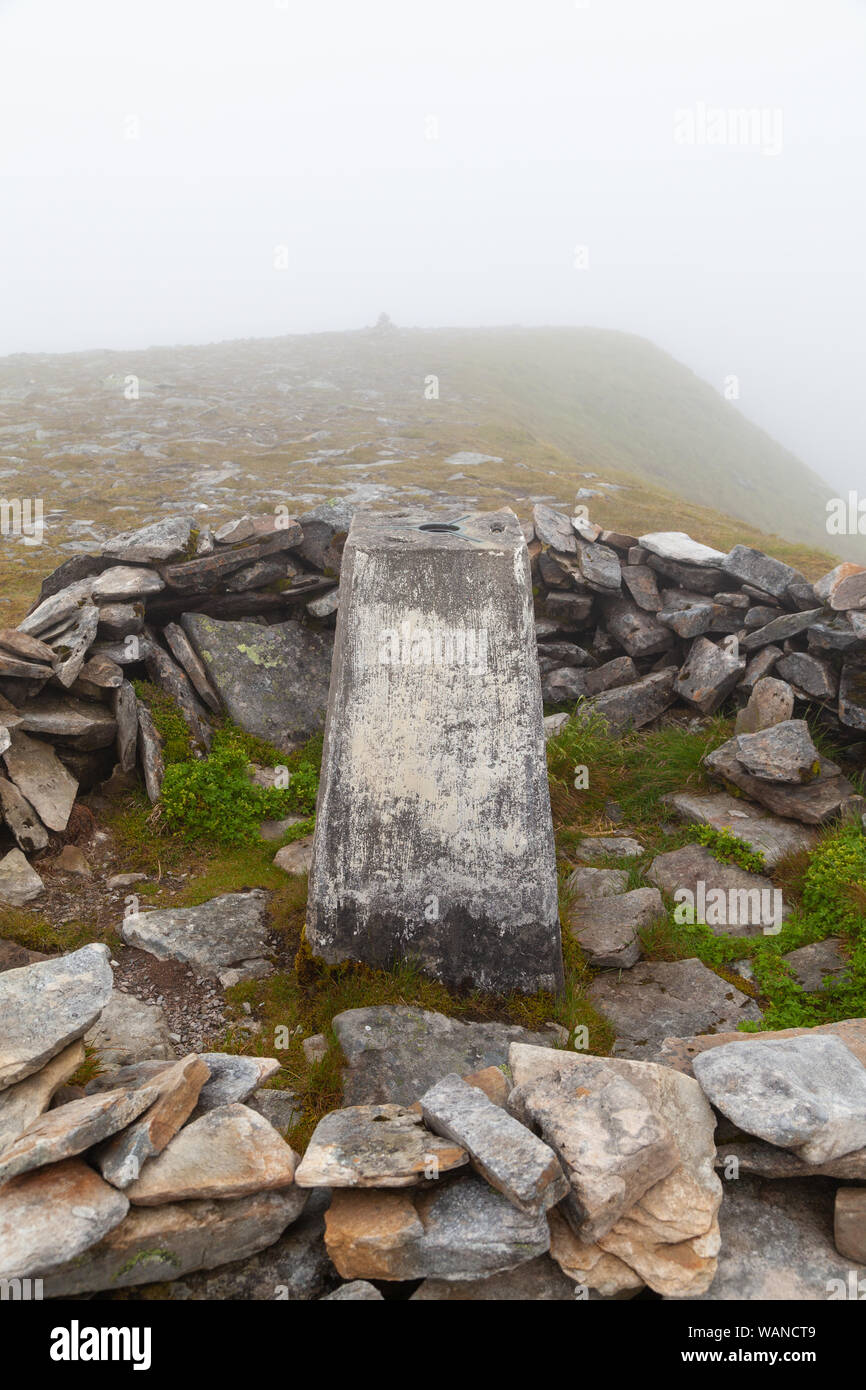 The trig point on top of the Corbett Ben Hee in foggy weather, Sutherland , Scotland. Stock Photo