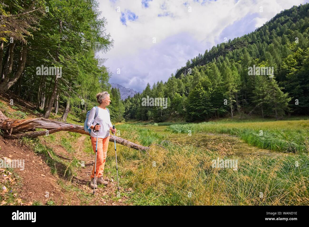 Woman hiker hiking looking at scenic view of mountain landscape . Adventure travel outdoors person standing relaxing  during nature hike Stock Photo