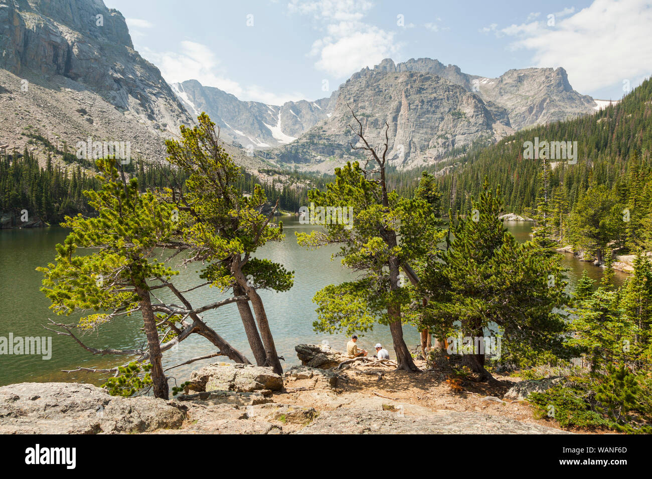 Hikers sit on the shore of The Loch, Rocky Mountain National Park, Colorado. Stock Photo