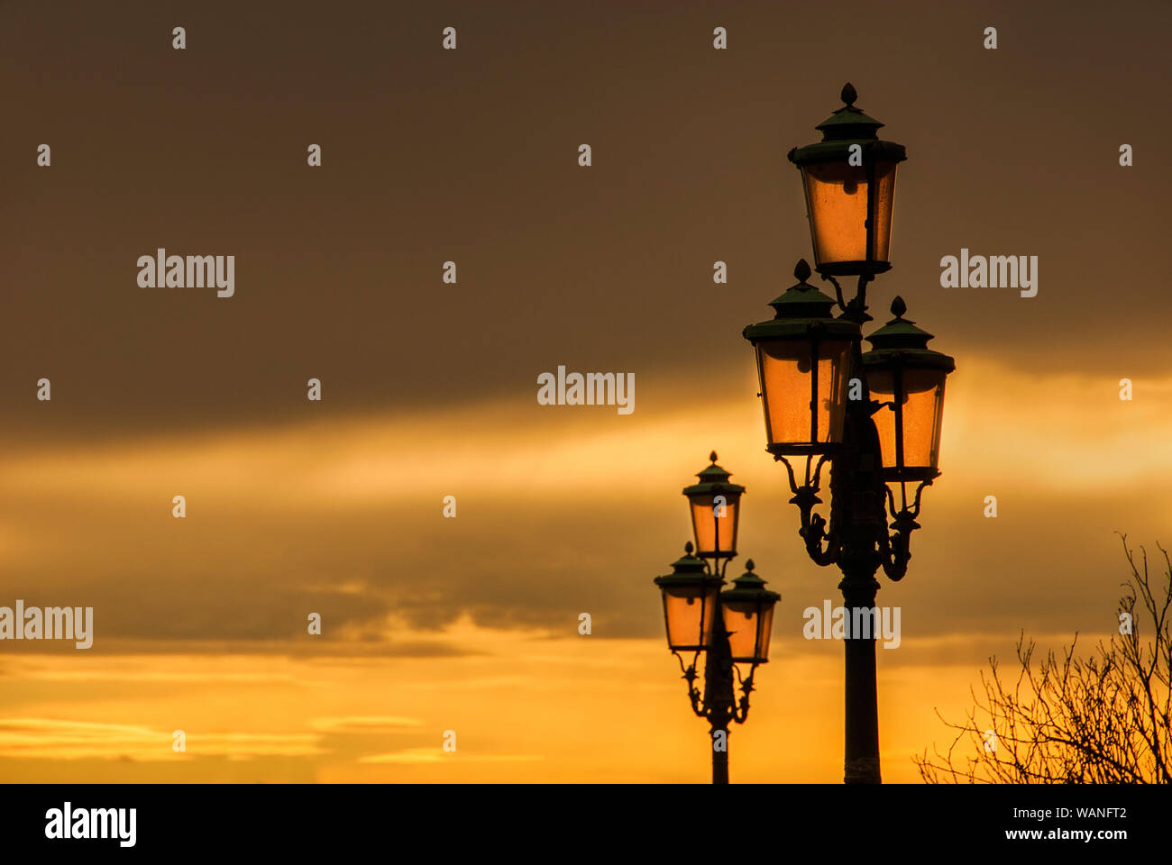 Old traditional Venice street lamps with golden sunset in a romantic ...