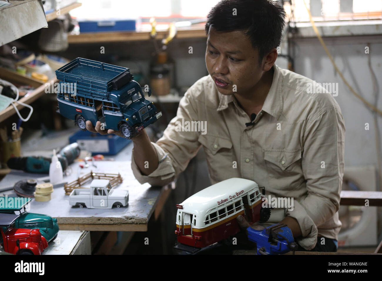 (190821) -- YANGON, Aug. 21, 2019 (Xinhua) -- Craftsman Zay Yar presents handicrafts at his workroom in Yangon, Myanmar, Aug. 20, 2019. Zay Yar is a craftsman who has been making wooden miniatures of vehicles dated back to bygone era in Myanmar's largest city Yangon for three years. Being into old generations' vehicles produced around World War II and were broadly used as public transports in Myanmar, Zay Yar initiated his model making hobby in 2016 after working at a auto body shop for a decade. TO GO WITH:Feature: Myanmar craftsman makes wooden miniatures of vehicles from bygone era (Xinhua Stock Photo