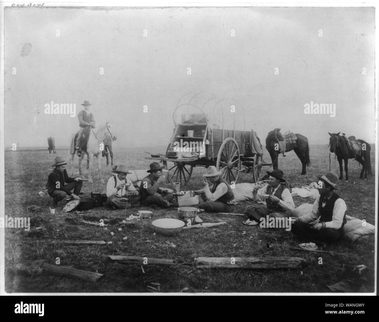 Cowboys eating out on the range, chuck wagon in background Stock Photo ...