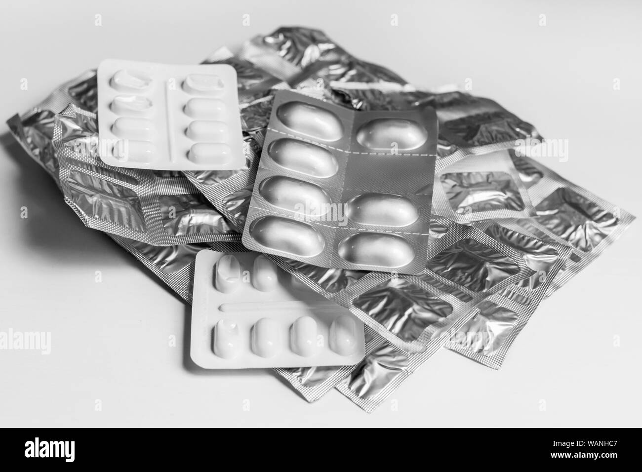 Blister packs of medicine tablets in a stack, on a plain background Stock Photo