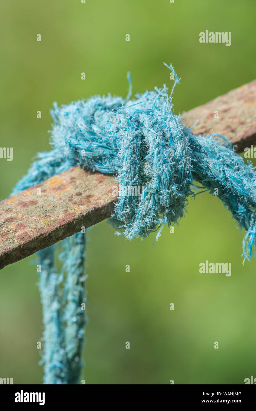 Thick industrial polymer rope tied round top of metal farm gate
