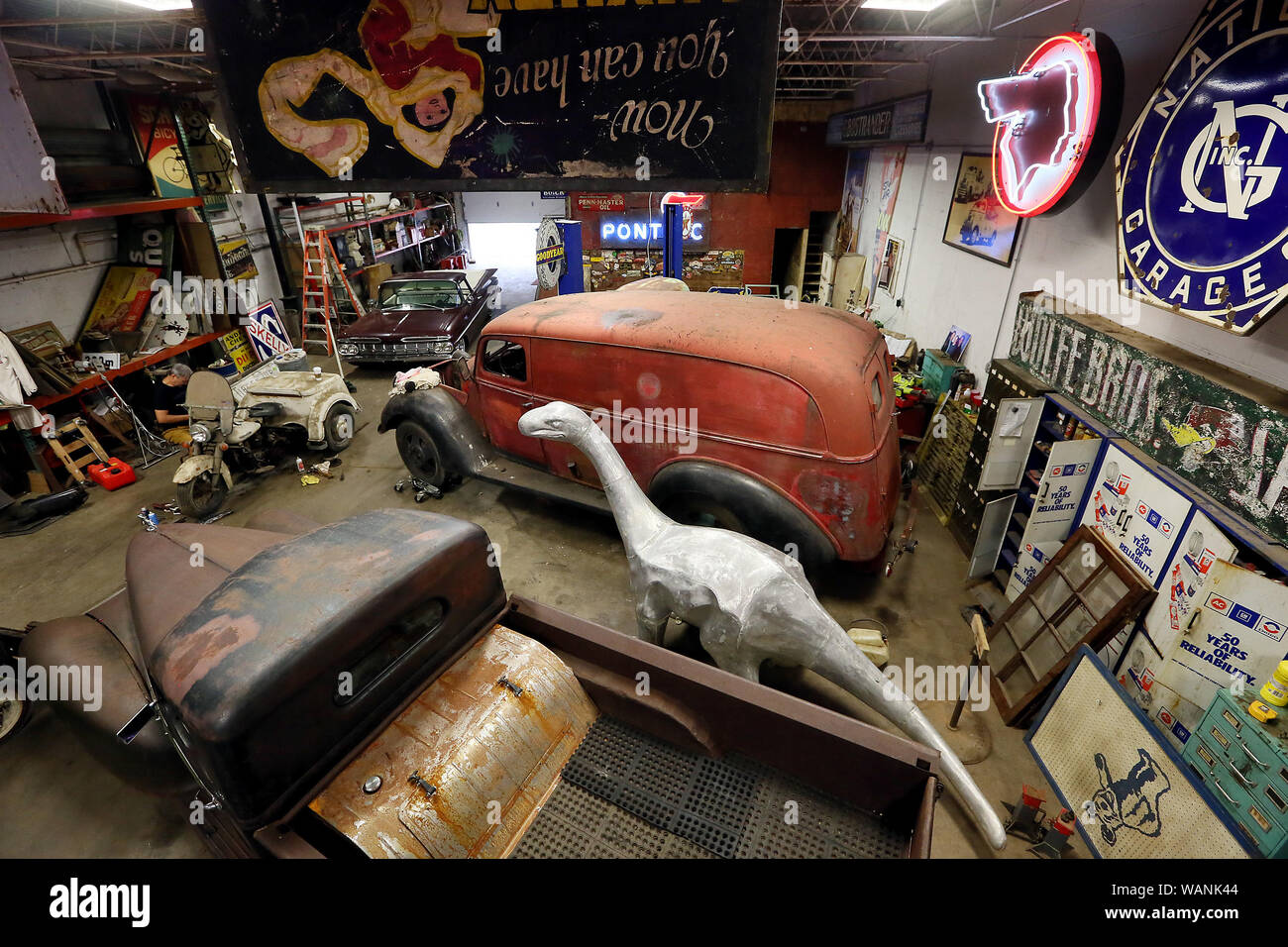 August 21, 2019, Davenport, Iowa, USA: Several classic vehicles and Dino The Sinclair dinosaur are part of Robb Wolfe's collection at his Davenport warehouse location. Wolfe is promoting the ''Davenport Americana'' show September 12-14, 2019 at the Mississippi Valley Fairgrounds. The event brings three shows together at one location, the Past Gas Car Show & Cruise, the Davenport Americana Show and the Premiere Petroliana Auction. (Credit Image: © Kevin E. Schmidt/Quad-City Times via ZUMA Wire) Stock Photo