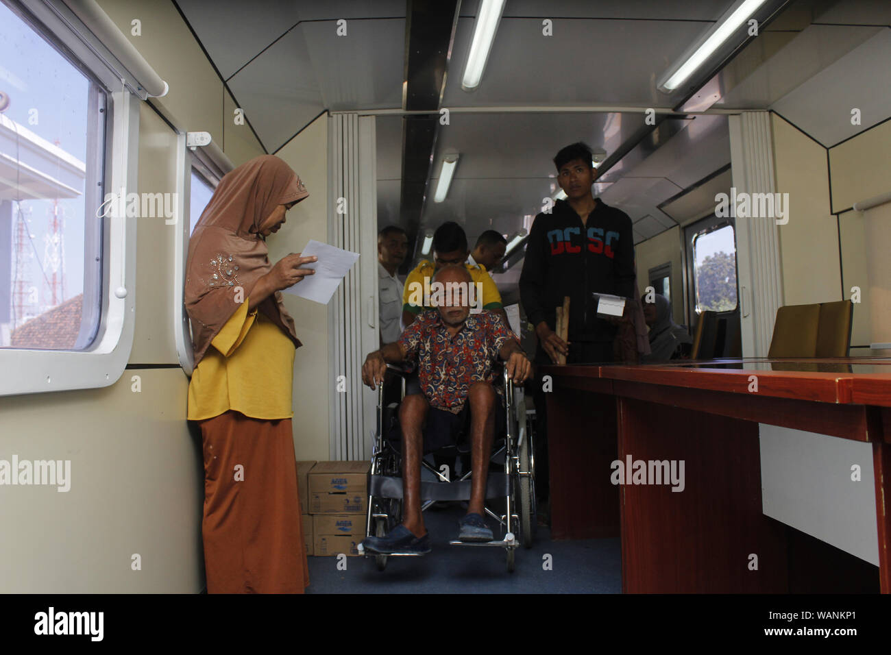 Madiun, Indonesia. 21st Aug, 2019. Officers assisted residents who were social service participants to the medical examination room above the Rail Clinic car at Saradan Station, Madiun Regency, Wednesday, August 21, 2019. Dozens of 7 Madiun Operational Area officers consisted of railfans, pharmacists and medical personnel serving various health complaints felt around 300 people get free medical treatment each year by PT. Indonesian Railways (Photo by Ajun Ally/Pacific Press) Credit: Pacific Press Agency/Alamy Live News Stock Photo