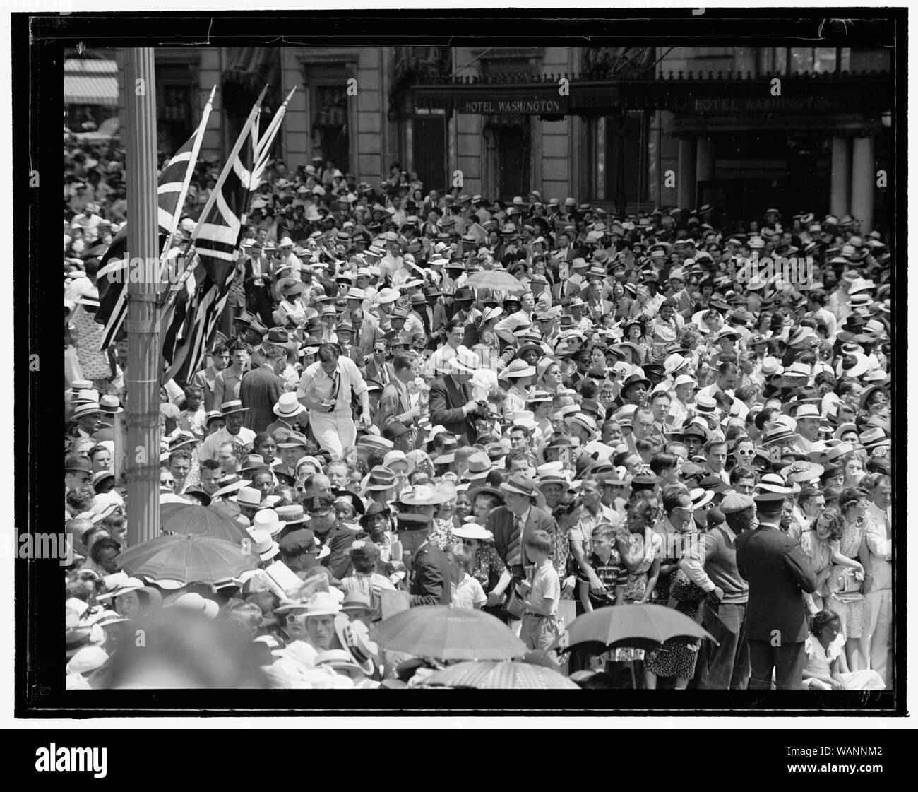 Crowd outside Hotel Washington, 15th Street and Pennsylvania Avenue, with British flags on nearby pole Stock Photo