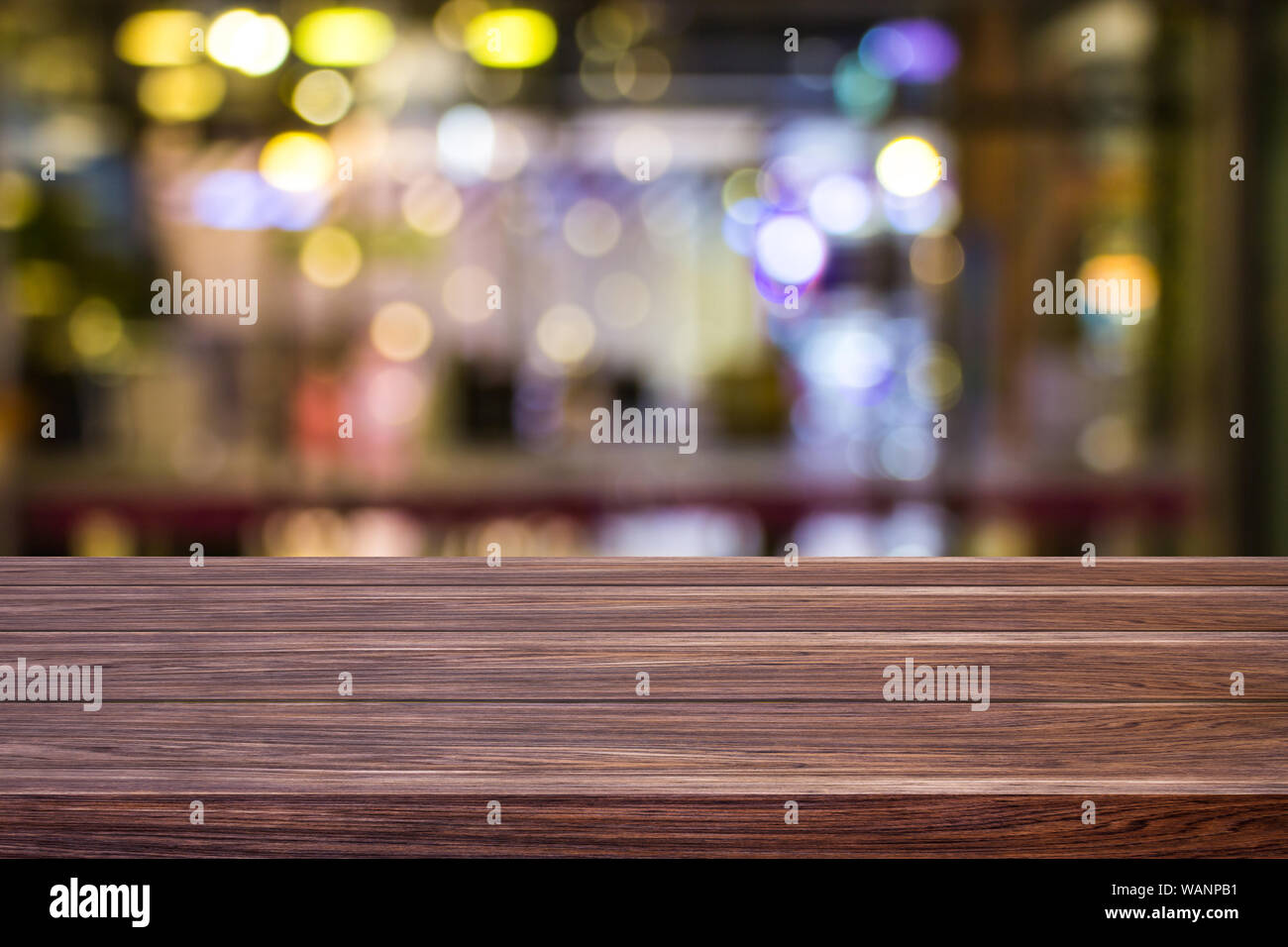 Blur cafe restaurant or coffee shop empty of dark wood table with blurred light gold bokeh abstract background for montage product display or design. Stock Photo