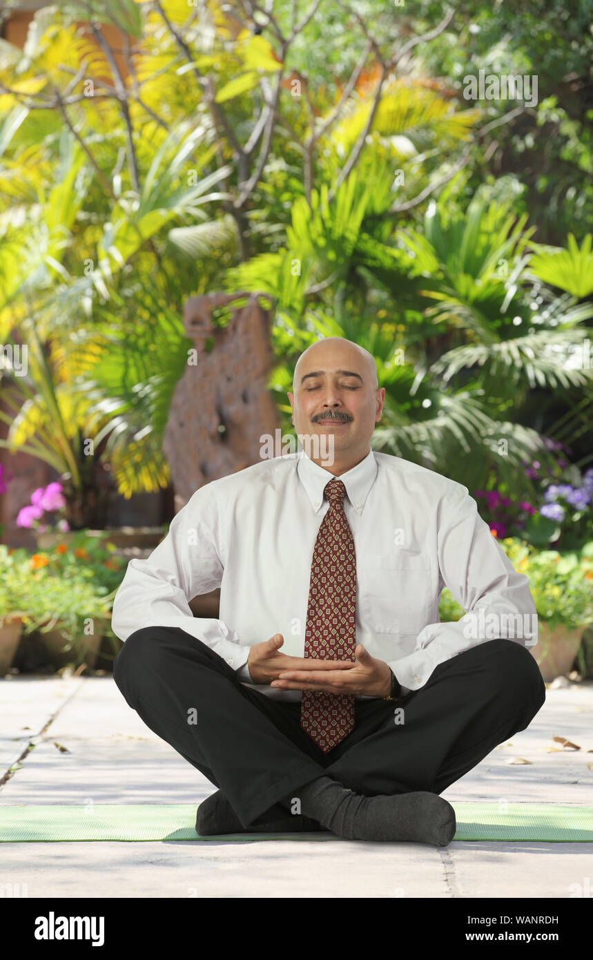 Businessman practicing meditation Stock Photo