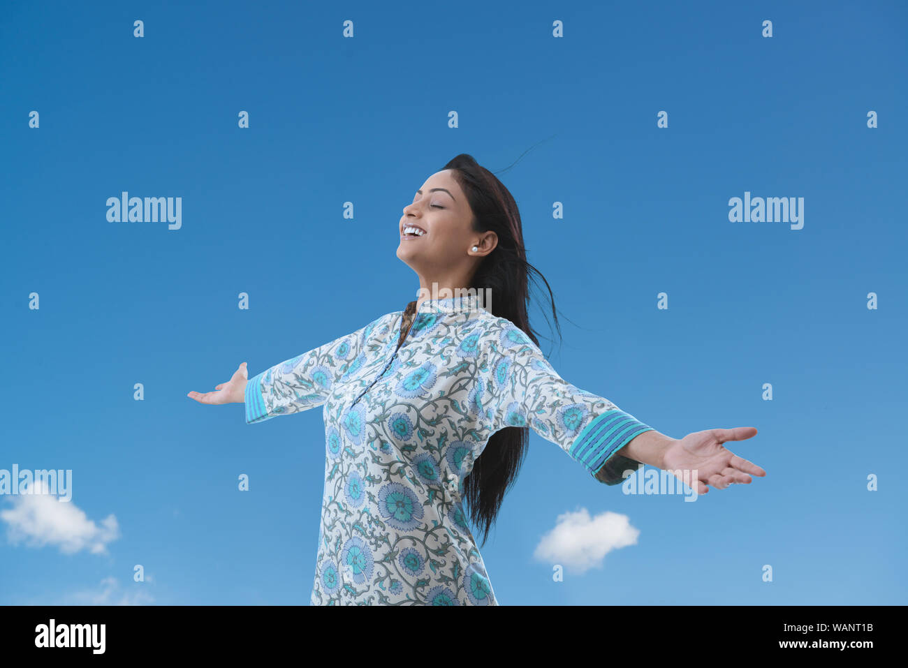 Young woman standing with her arm outstretched Stock Photo