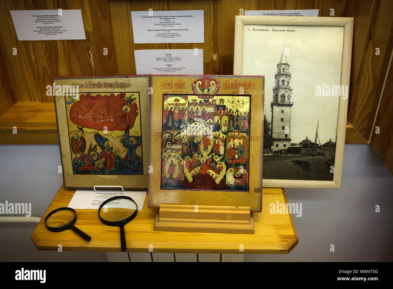 Nevyansk icons on display in the Nevyansk Icon Museum (Nevyanskaya Ikona) in Yekaterinburg, Russia. The leaning tower in the town of Nevyansk is depicted in the old photograph at the right. Stock Photo