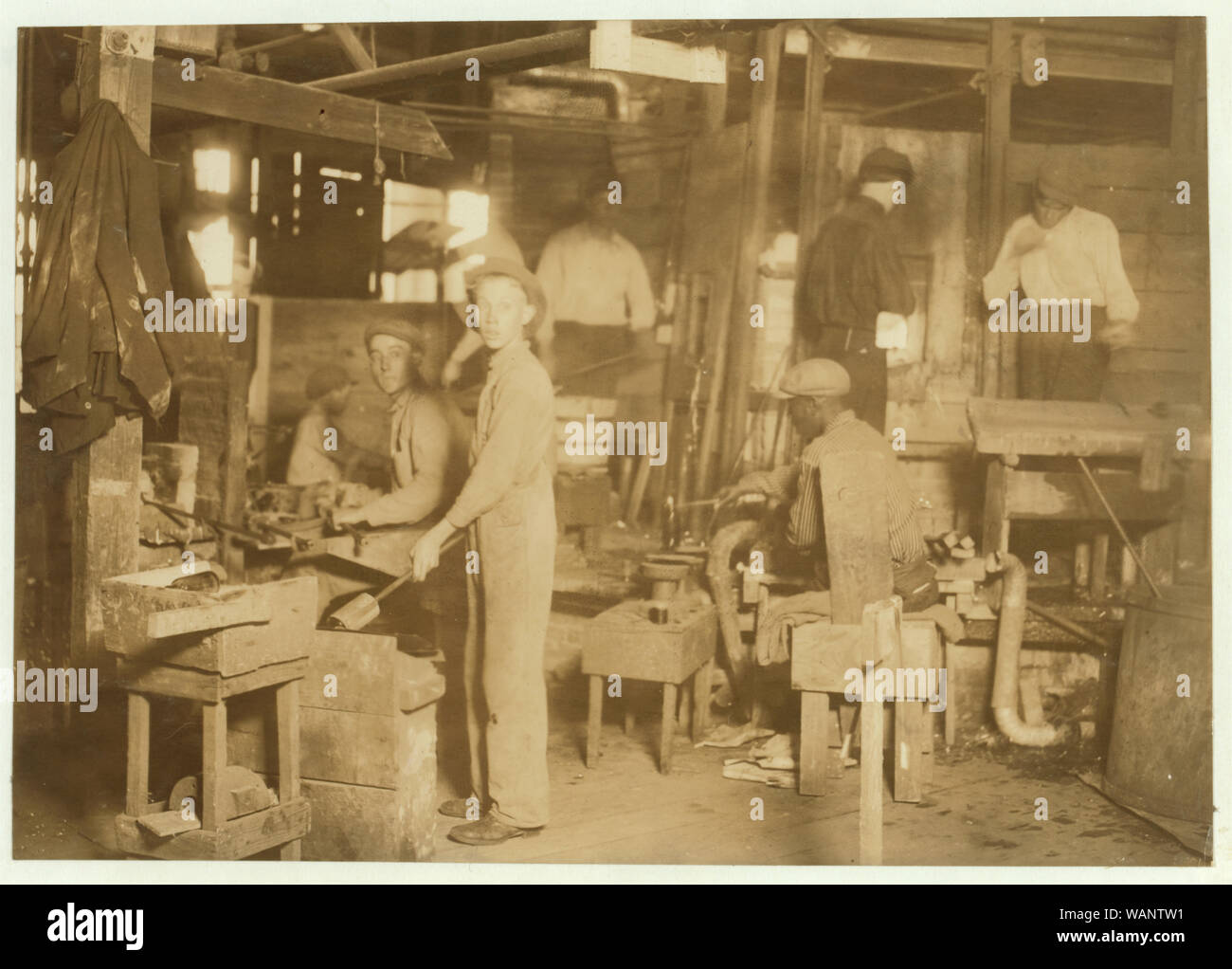 Cumberland Glass Works, Bridgeton, N.J. A young holding-mold boy is seen, dimly, in middle distance to left of centre. Negroes, Greeks and Italians are being employed in many glass houses. Abstract: Photographs from the records of the National Child Labor Committee (U.S.) Stock Photo