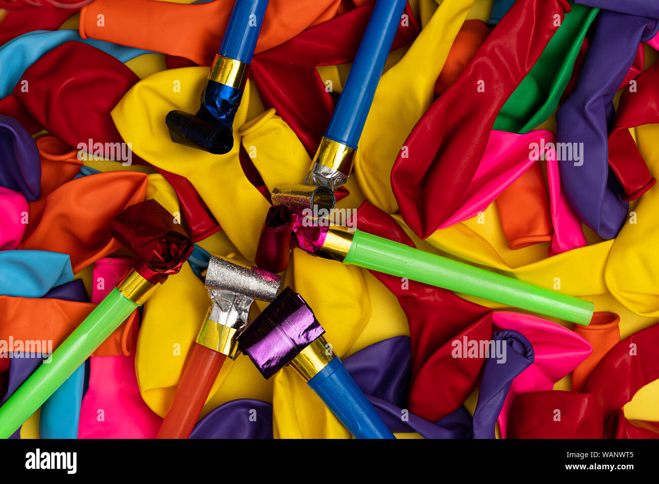 Birthday party whistles and colorful deflated balloons. Colorful