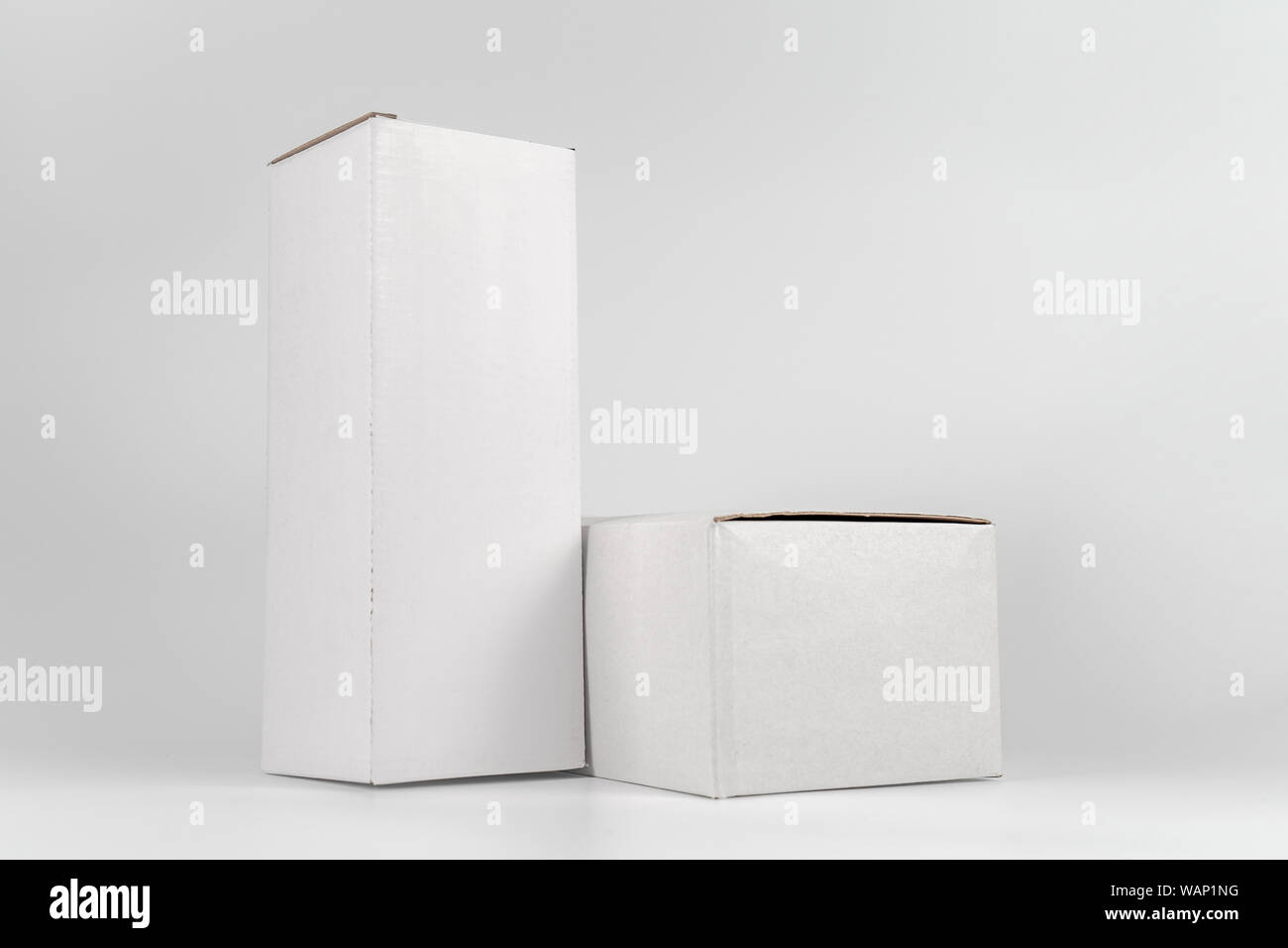 White two paper boxes - tall and fat lay on the white background in studio shot with clipping paht. Stock Photo