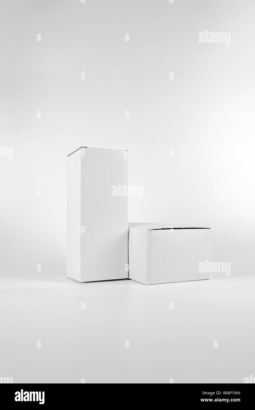 White two paper boxes - tall and fat lay on the white background in studio shot with clipping paht. Stock Photo