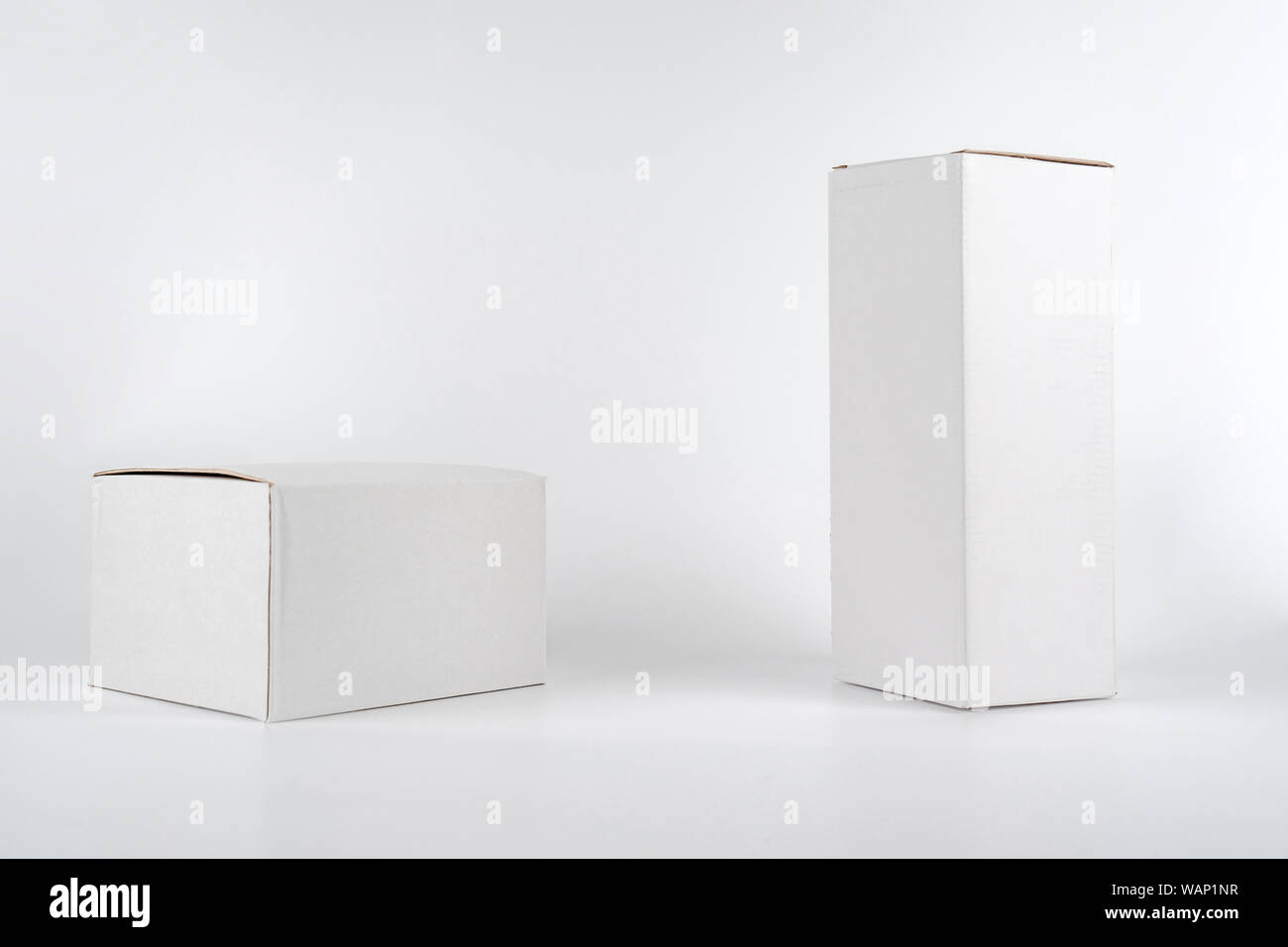 White two paper boxes - tall and fat lay on the white background in studio shot with clipping paht. Stock Photo