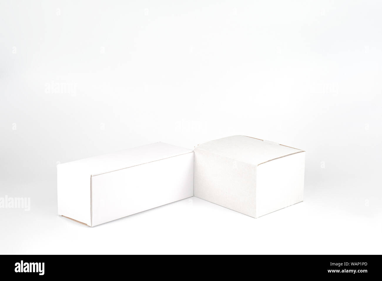 White two paper boxes - tall and fat lay on the white background in studio shot with clipping paht. Stock Photo